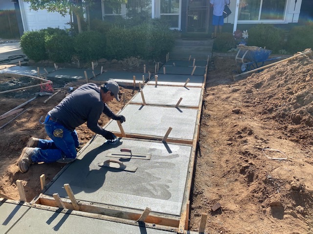 Cruz Landscaping and Design crew member troweling a freshly poured concrete walkway in the Greater Sacramento Area